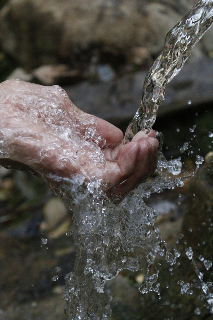 pexels-photo-66346-66346 Close-up of a human hand under a stream of clear, flowing water.