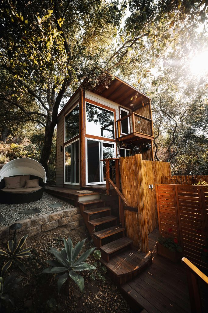 pexels-photo-8755443-8755443 A stylish wooden cabin amidst green foliage, ideal for a serene getaway.